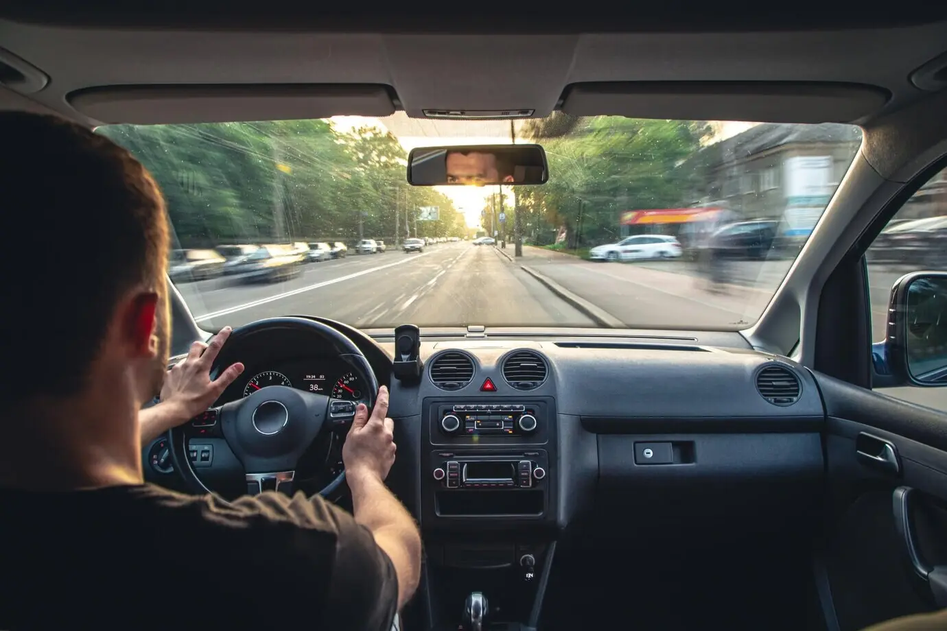 Hands on the steering wheel while driving fast, viewed from inside the car.